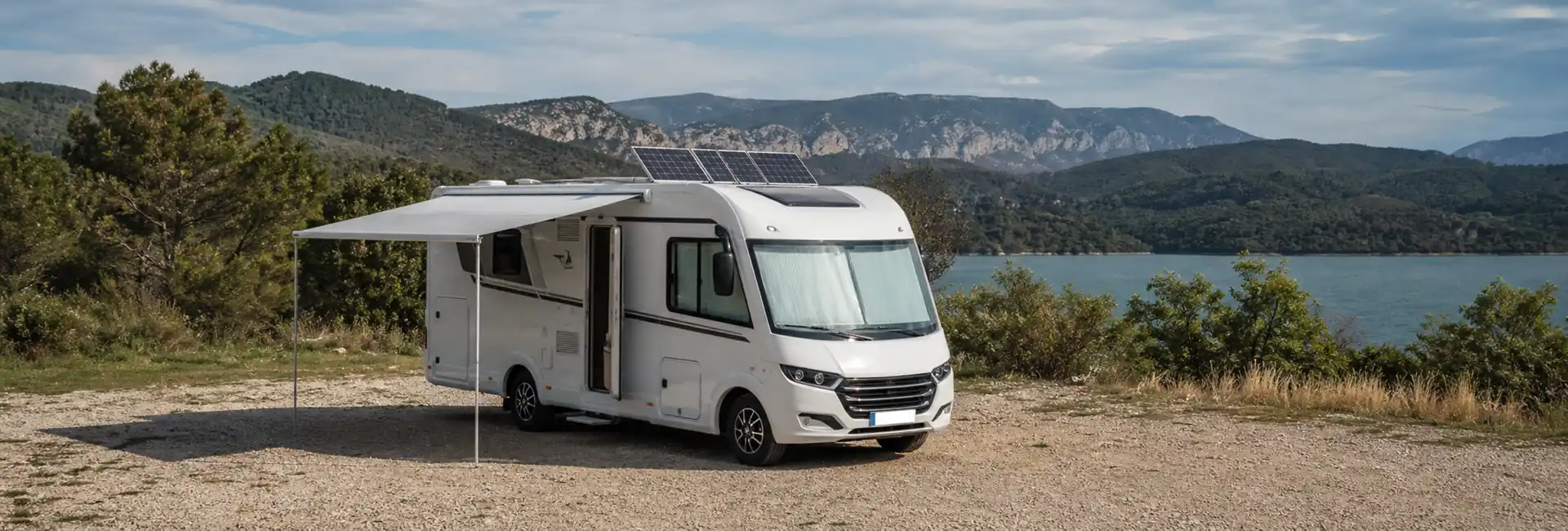 Homologar Autocaravana 1 Autocaravana en zona de acampada, naturaleza o ruta con placas solares y toldo desplegados