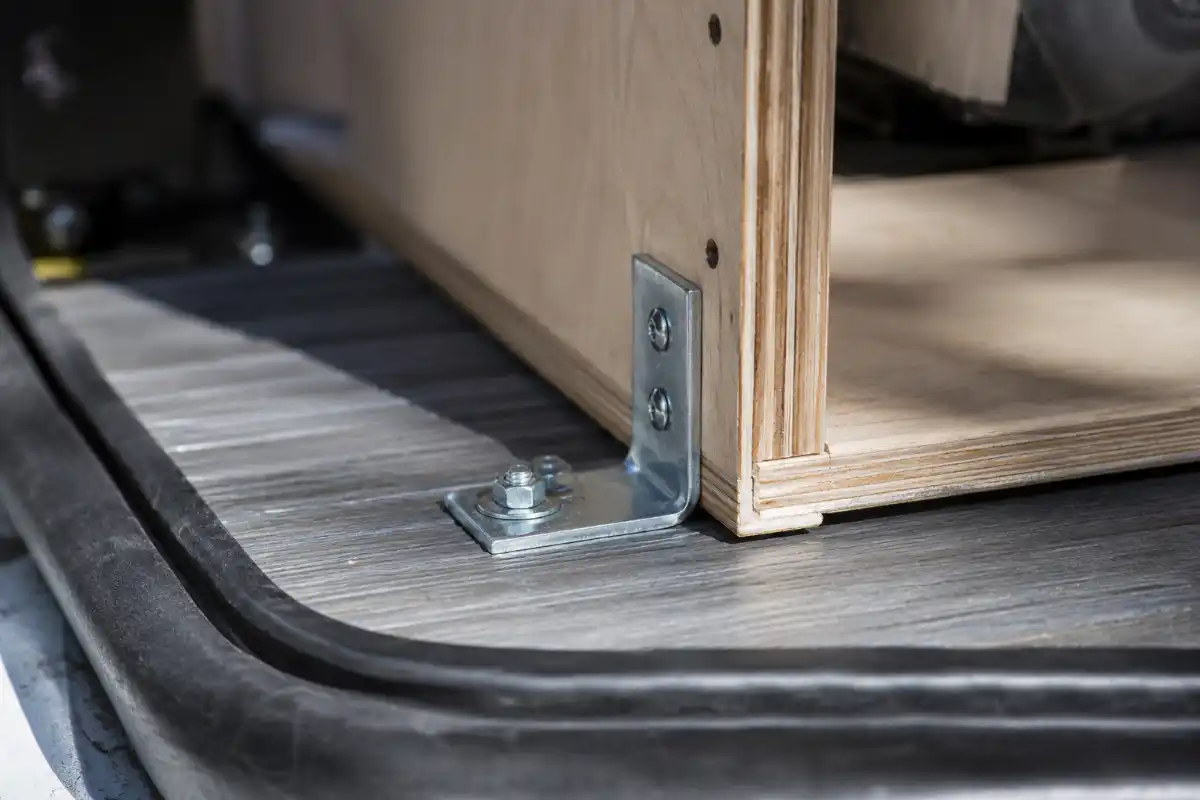 Mobiliario 3 Detalle de fijación de mueble al suelo de furgoneta con tornillería y escuadras homologar camper mobiliario